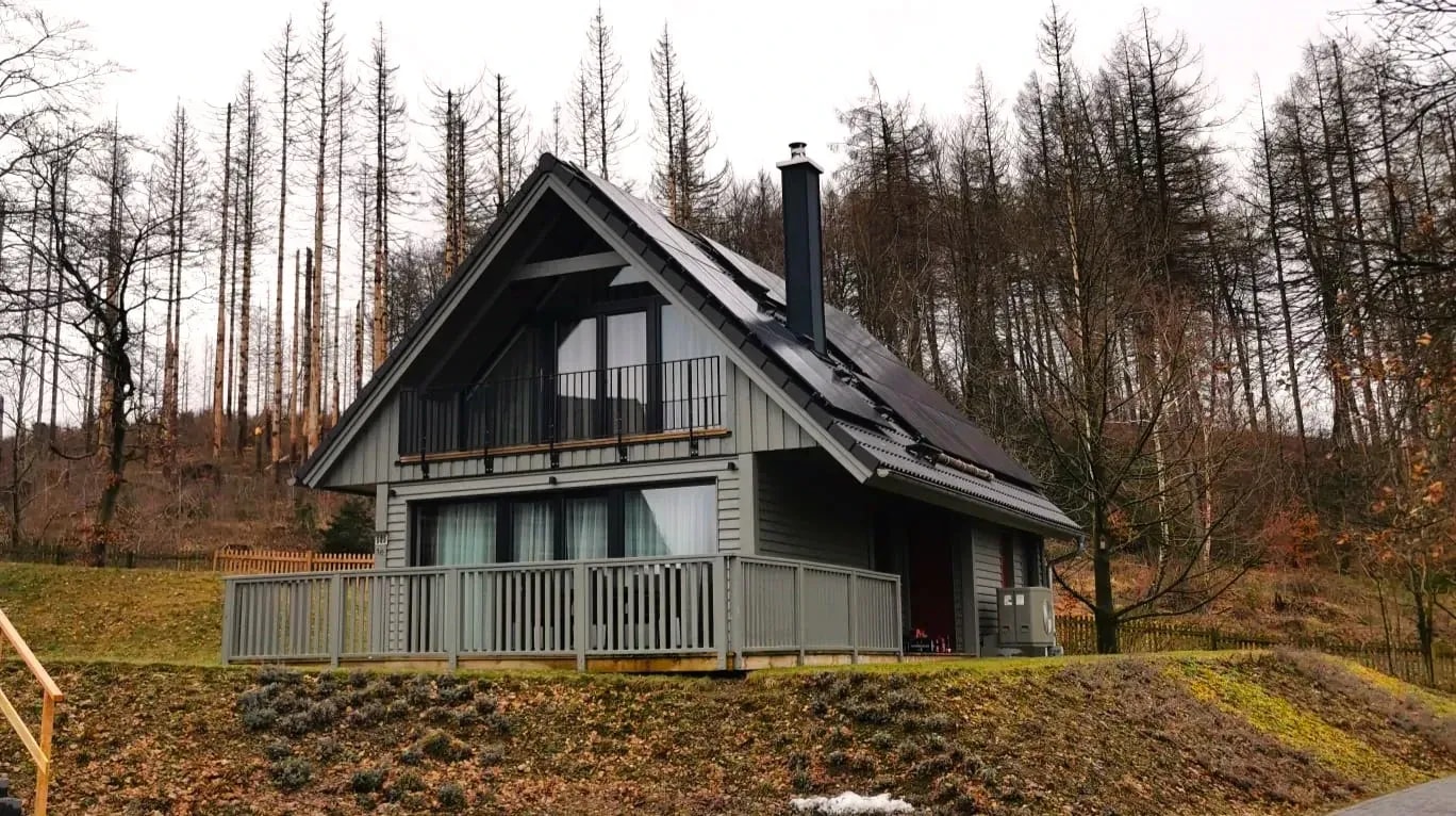 Ferienhaus mit Photovoltaikanlage auf dem Dach am Waldrand als nachhaltige Energielösung