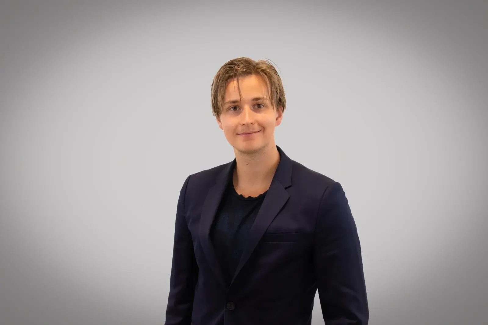 Portrait eines Mitarbeiters von GLC Energy im Anzug vor grauem Hintergrund